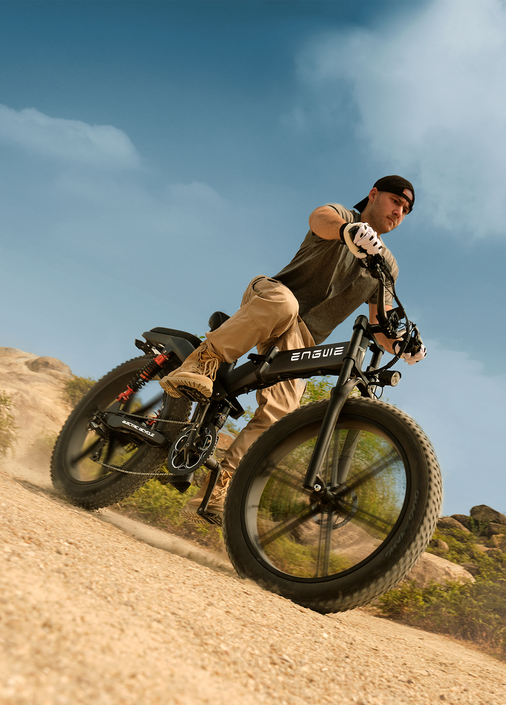 a man rides an engwe x26 fat tire electric bike on the sand