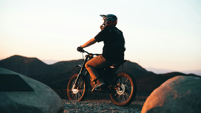 a man rides an e-bike in the sunset