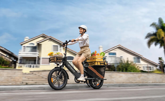 a woman rides an engwe le20 carrying groceries on the road