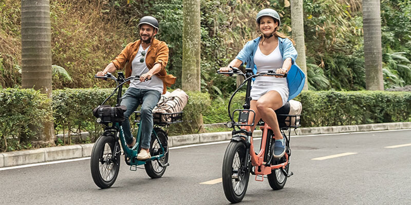 a man and a woman wearing bike helmet ride engwe l20 2.0 electric bike on the road
