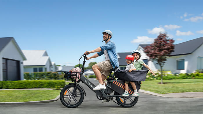 a man riding an engwe le20 cargo e-bike with 2 children