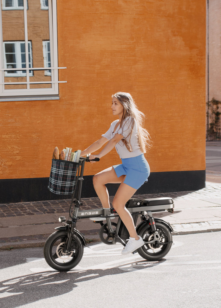 a girl rides a gray engwe t14 electric folding bike on the street