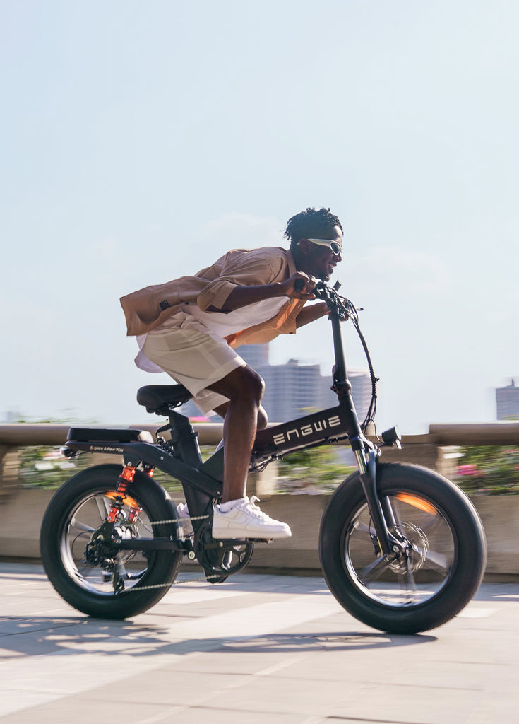 a man rides a black engwe x20 fat tire electric bike on the road