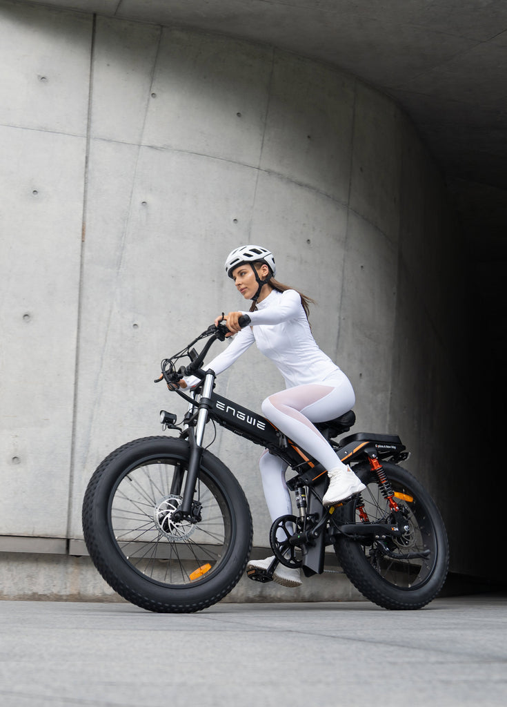 a woman rides a black engwe x24 folding e-bike